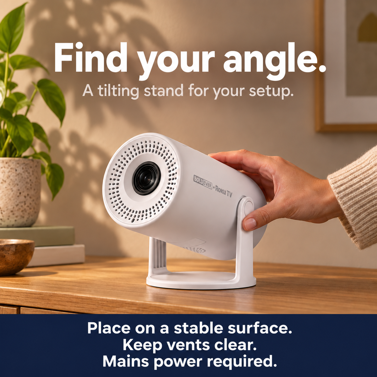 A hand adjusts the white Boldever Roku TV projector on its tilting stand.